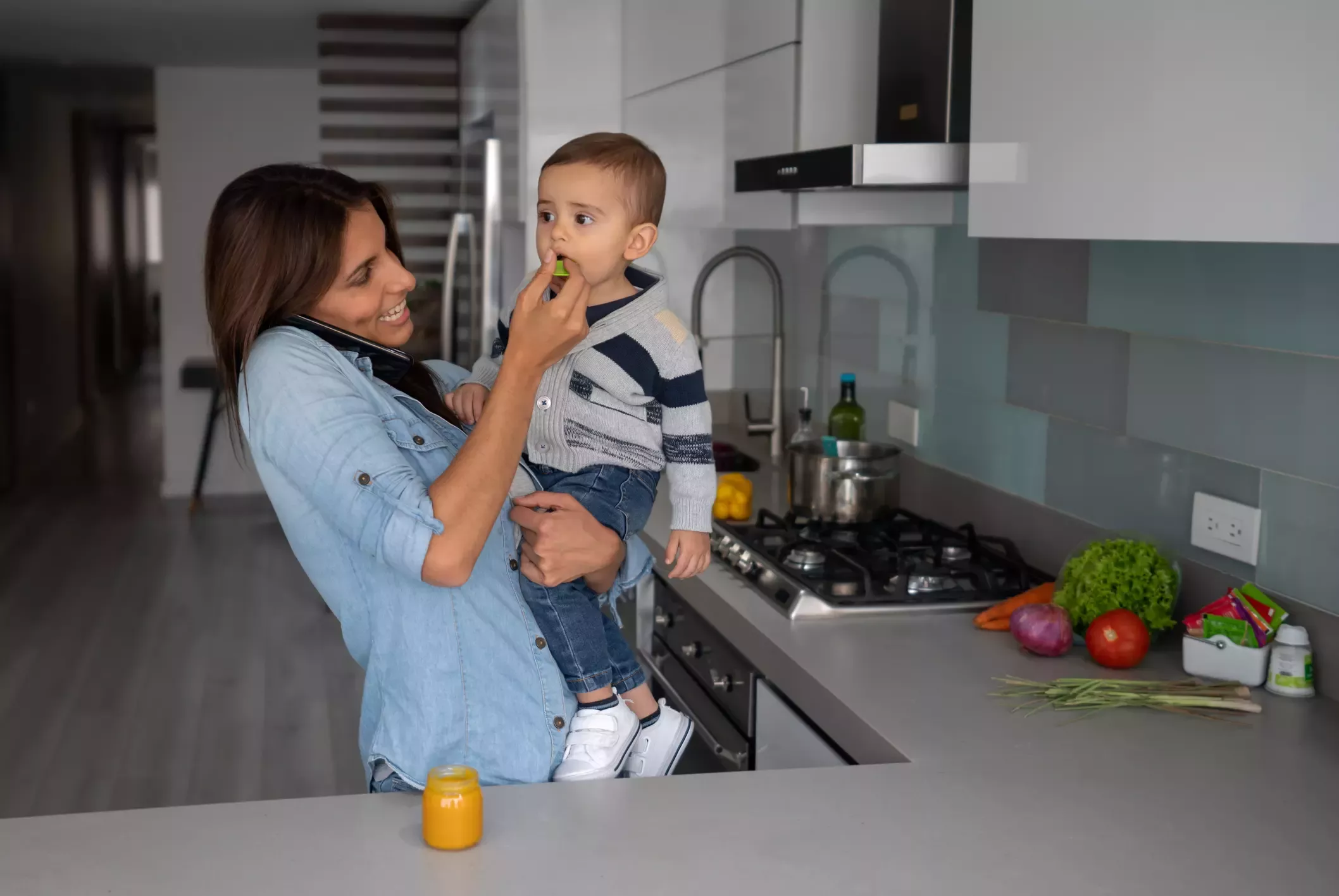 Una madre cargando a su niño, dándole de comer